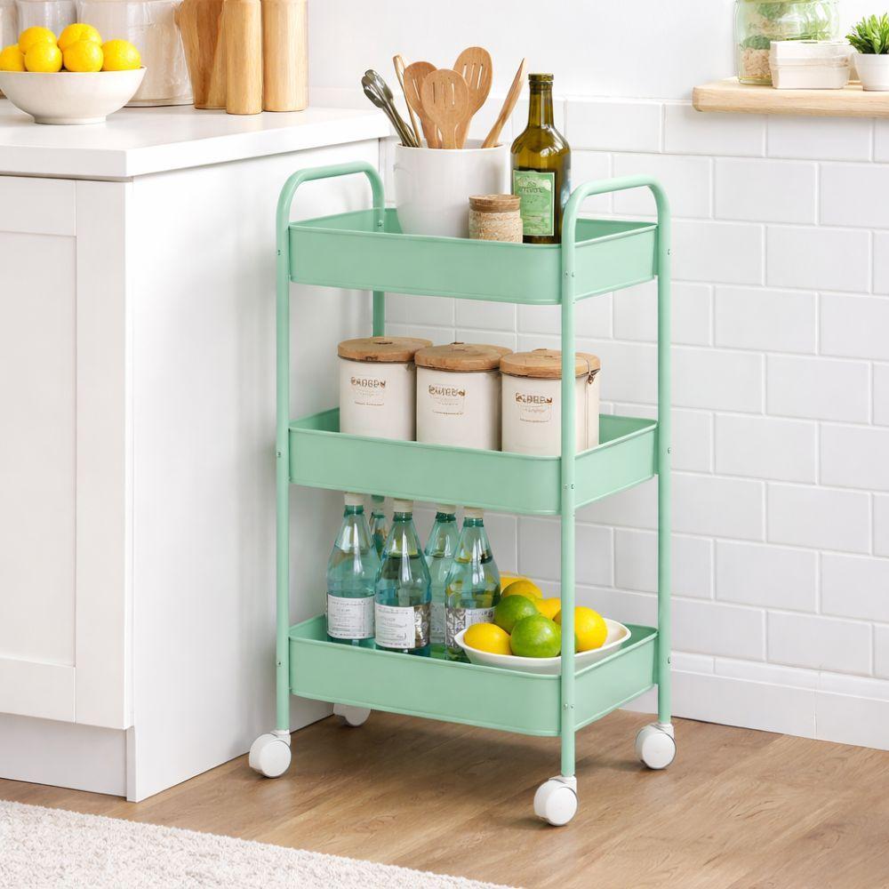 Carrello turchese a tre ripiani in uso in cucina con bottiglie, limoni e contenitori