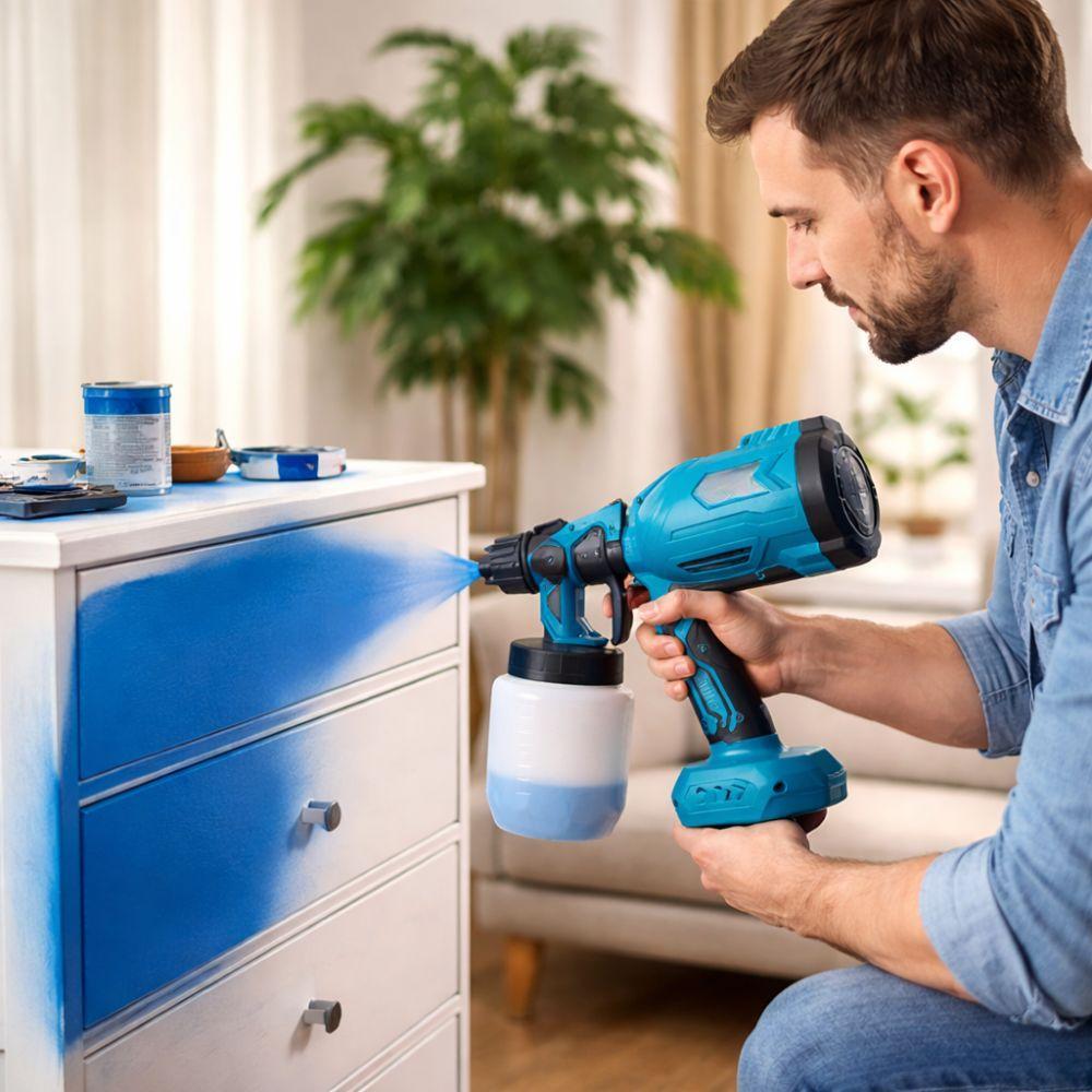 Uomo utilizza verniciatore a spruzzo per verniciare mobile blu in ambiente interno
